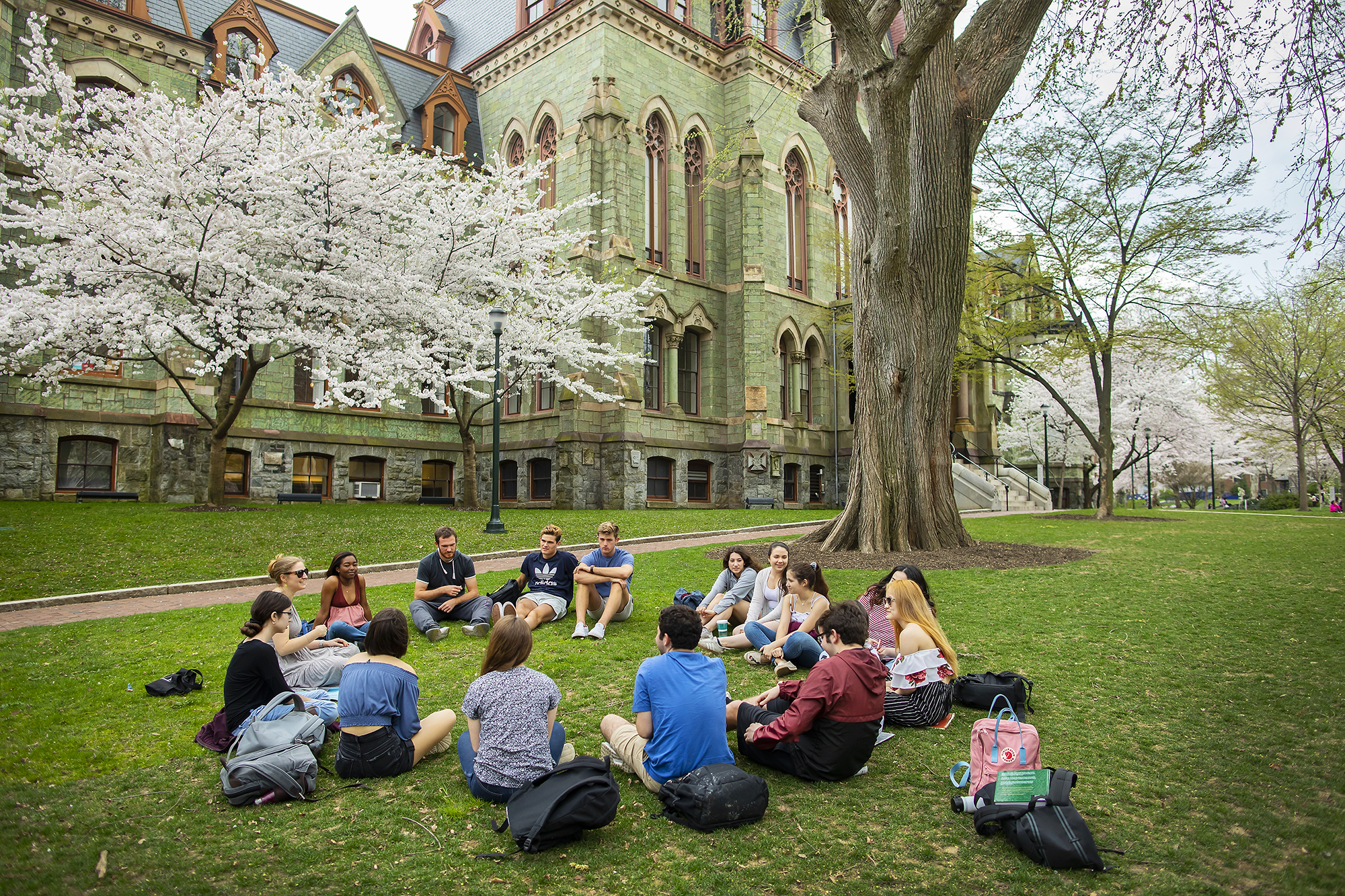 students sitting in a circle on college green